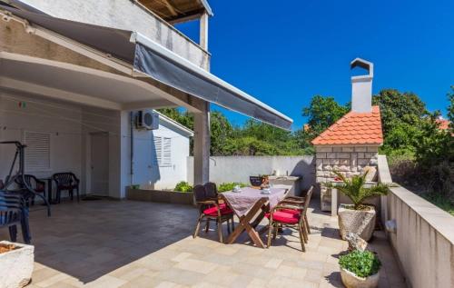 a patio with a table and chairs and a fireplace at Slanac 3 in Veli Iž