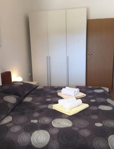 a bedroom with a bed with towels on it at Slanac 3 in Veli Iž