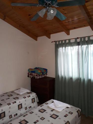 um quarto com 2 camas e uma ventoinha de tecto em Complejo Camila em Villa Carlos Paz