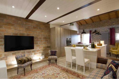 una cucina e un soggiorno con un muro di mattoni di Loft Giuly a Vignanello