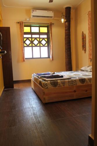 a bedroom with a bed in a room with a window at Sai Homestay in Malvan