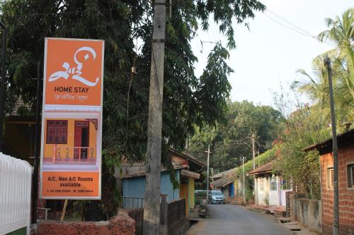 a sign on a pole next to a street at Sai Homestay in Malvan