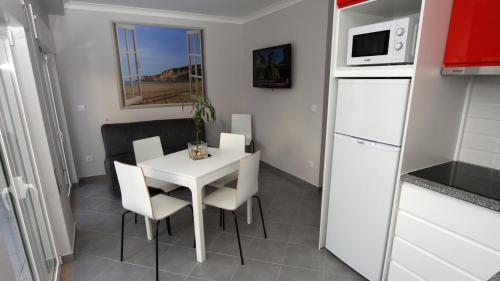 ナザレにあるCasa do Terraçoの小さなキッチン(白いテーブル、椅子付)