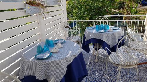 two tables and chairs on a patio with blue dishes at B&B Vistamare Suite in Agropoli