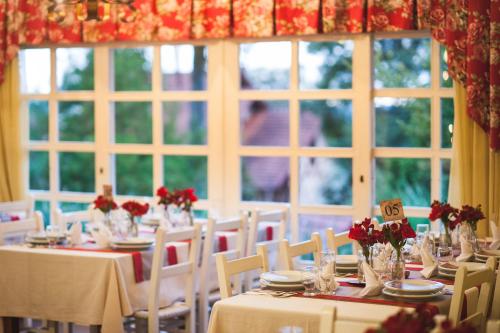 a dining room with tables and chairs and windows at Hotel Pousada da Neve in Nova Petrópolis