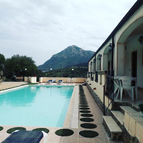 a swimming pool with a mountain in the background at Hotel Valle del Cedrino in Galtellì