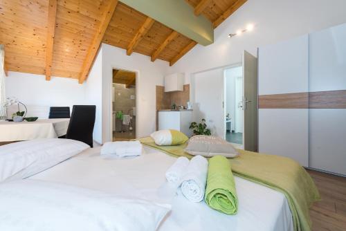 two beds in a bedroom with wooden ceilings at Guesthouse Miranda NP Krka in Lozovac