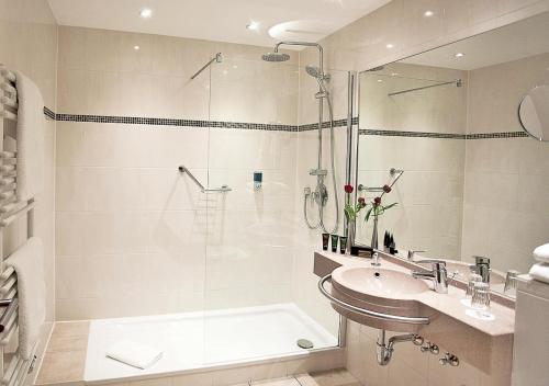 a bathroom with a shower and a sink and a tub at Hotel Panorama in Heidelberg