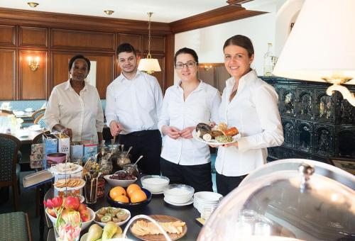 a group of people standing in a kitchen with a plate of food at Hotel Restaurant Krehl's Linde in Stuttgart