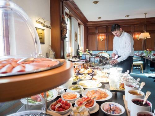 a man standing in front of a buffet of food at Hotel Restaurant Krehl's Linde in Stuttgart