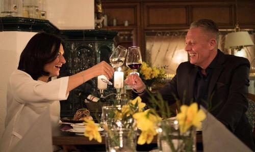 a woman and man sitting at a table with wine glasses at Hotel Restaurant Krehl's Linde in Stuttgart