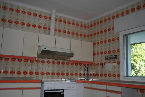 a kitchen with white cabinets and a window at Casa Rural El Rivero in Jaraiz de la Vera
