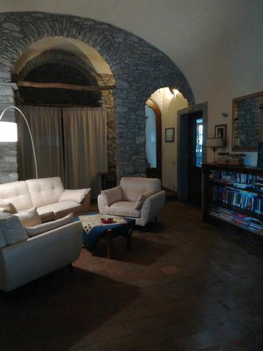 a living room with two couches and a stone wall at Giunasco in Bagnone
