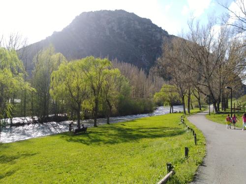 a park next to a river with a mountain at Ca de Géraldine in El Pont de Suert