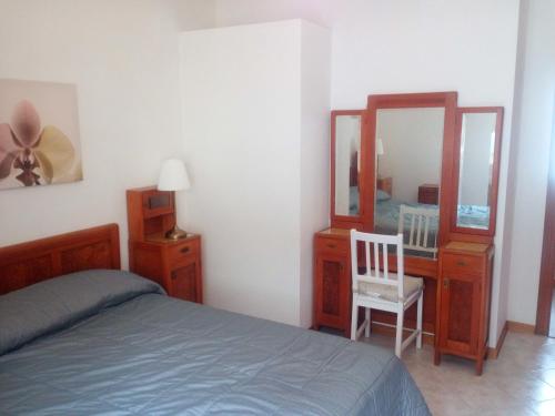 a bedroom with a bed and a dresser and a mirror at Appartamento Perco Riva Slataper in Grado