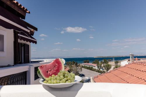 a bowl of grapes and a bowl of watermelon at Agistri Hotel in Skala