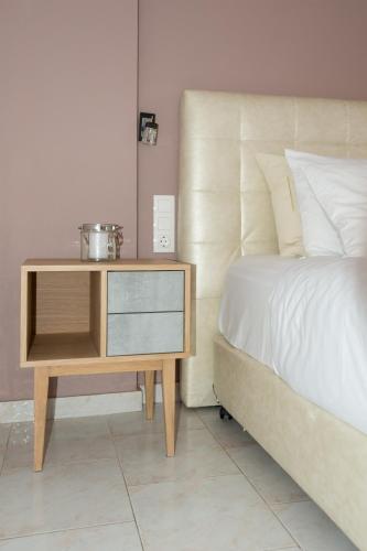 a bed with a wooden nightstand next to a bed sidx sidx sidx at The Wave in Sidari