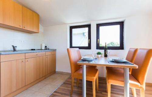 a kitchen with a table and some chairs and a table and a counter at Slanac in Veli Iž