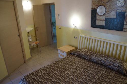ein Schlafzimmer mit einem Bett und einen Flur mit einem Stuhl in der Unterkunft B&B Lo Sparviero in Civita