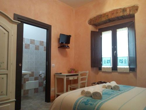 a bedroom with a bed and a bathroom with a shower at B&B Sa Lumenaria "da Raimonda" in Sorgono