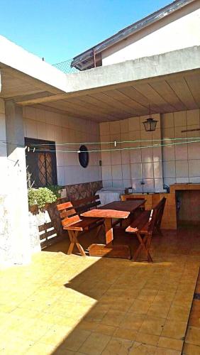 un patio al aire libre con mesa de madera y sillas en Casa de Campos do Jordão, en Campos do Jordão