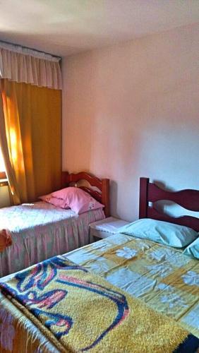 a bedroom with two beds and a blanket on the bed at Casa de Campos do Jordão in Campos do Jordão