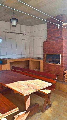 a room with a wooden table and a brick oven at Casa de Campos do Jordão in Campos do Jordão