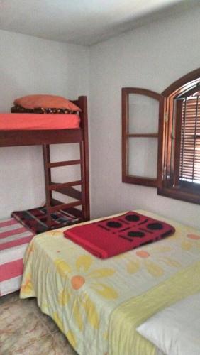 a bedroom with two bunk beds and a window at Casa de Campos do Jordão in Campos do Jordão