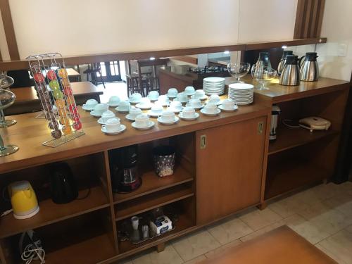 Pousada Hencke Haus في كانيلا: طاولة عليها أكواب بيضاء وصحون