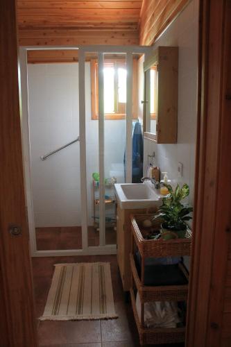 a small bathroom with a sink and a shower at Quinta da Pavoa - Cottage House in Vila Franca do Campo