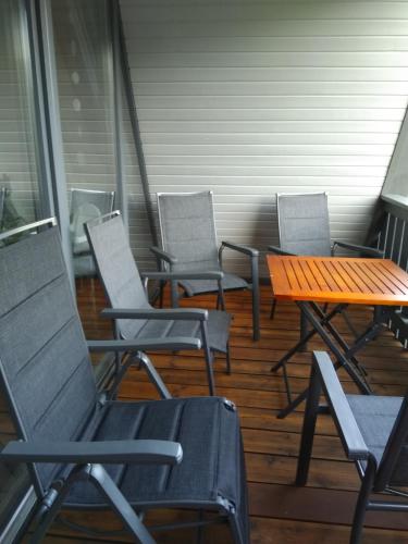 a porch with chairs and a wooden table and a table at Ferienhaus in der Rhön Sitzmann in Bischofsheim an der Rhön