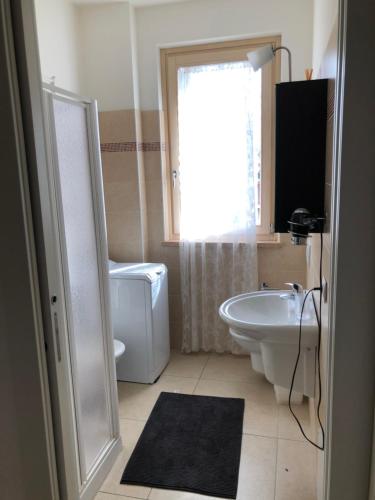 een badkamer met een wastafel, een toilet en een bad bij appartamenti vespucci 16 in Bardolino