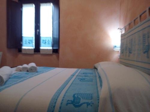 a bedroom with a bed with towels and slippers at B&B Sa Lumenaria "da Raimonda" in Sorgono