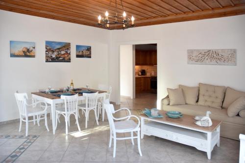 a living room with a table and a couch at Hydra's Pearl - White Pearl in Hydra