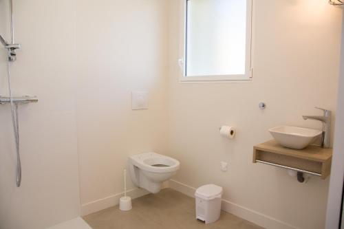 a white bathroom with a sink and a toilet at Albipavillon in Albi