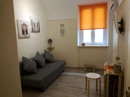 een woonkamer met een bank en een raam bij Casa Mirka in Sanremo