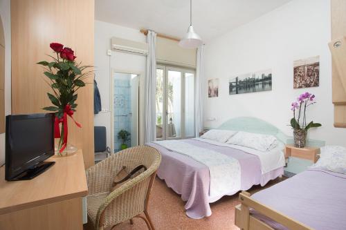 - une chambre avec un lit et une télévision dans l'établissement Hotel Gianlore, à Milano Marittima