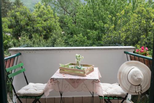 a table with a box of flowers on a balcony at Melina's House in Tramonti
