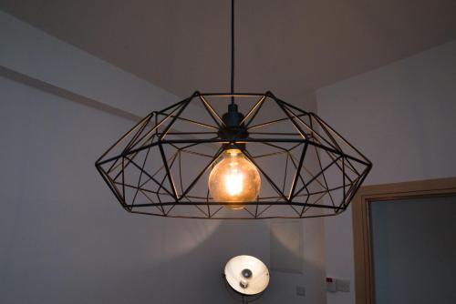 a ceiling light with a light bulb in a room at MCPlaces Holiday Apartments in Paphos City