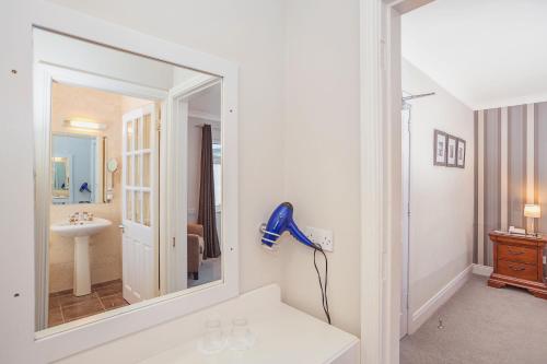 Baño blanco con espejo y lavabo en Ardree House B&B en Killarney