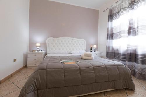 a bedroom with a large bed with a large window at Melina's House in Tramonti