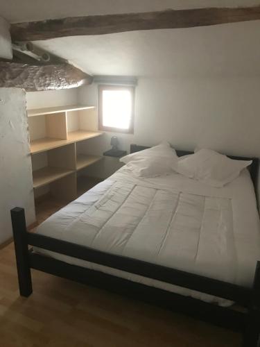 a bedroom with a large bed with a window and a window at Maison de charme in Concourson-sur-Layon