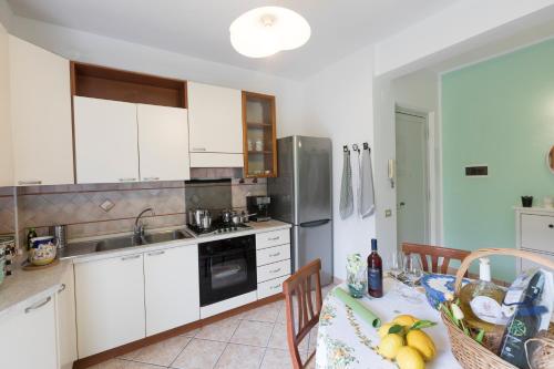a kitchen with white cabinets and a table with food on it at Melina's House in Tramonti