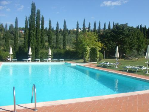 a large swimming pool with chairs and umbrellas at Podere il Vecchio Mulino in San Gimignano