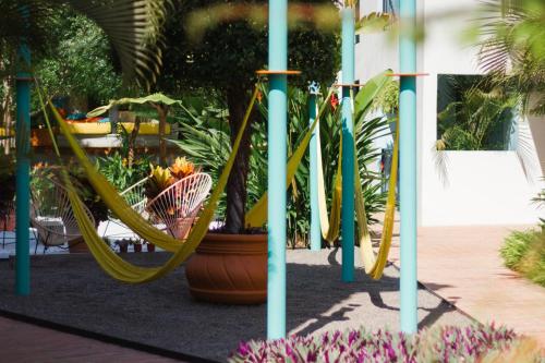 a playground with a yellow slide in a garden at San Trópico Boutique Hotel & Peaceful Escape in Puerto Vallarta
