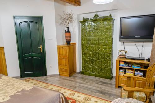 a living room with a green cabinet and a tv at Tündérgyöngye Apartmanház in Zirc