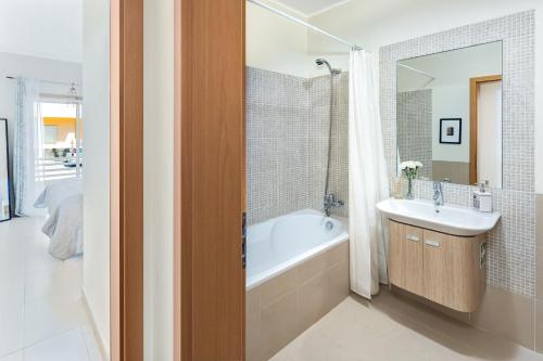 La salle de bains est pourvue d'une baignoire et d'un lavabo. dans l'établissement Mr. Stuart House, à Cabanas de Tavira