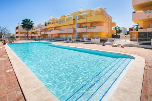 a swimming pool in front of a building at Mr. Stuart House in Cabanas de Tavira