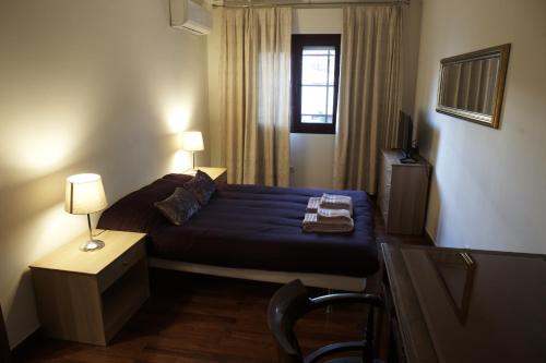 um quarto com uma cama, uma cadeira e uma janela em Happily Ever Lisbon em Lisboa