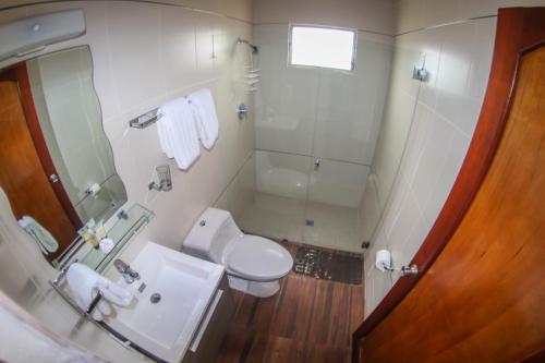 a bathroom with a toilet and a sink and a shower at Hotel Rebequet in Boquete